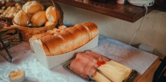 Szwedzki stół śniadaniowy z pieczywem, szynką i serem na obrusie