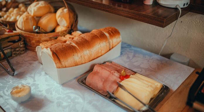 Szwedzki stół śniadaniowy z pieczywem, szynką i serem na obrusie